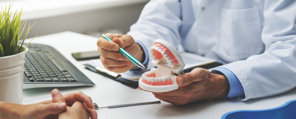 Dentysta i pacjent omawiający planowane leczenie zębów w gabinecie stomatologicznym, symbol profesjonalnej opieki dentystycznej.