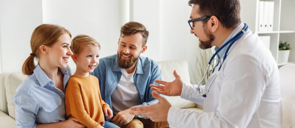 Lekarz,, korzystający z ubezpieczenia zdrowotnego INTER Polska z pomocą prawną, rozmawia z chłopcem i jego rodzicami - konsultacja pediatryczna i troska o dziecko.