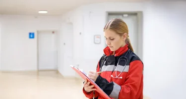 Ratowniczka medyczna w czerwonej kurtce korzysta z ubezpieczenia OC dobrowolnego dla medyków z ekspozycją HIV/WZW od INTER Polska.