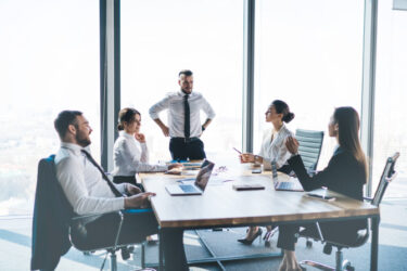 Pracownicy biura w trakcie spotkania rozmawiają o benefitach i ubezpieczeniu zdrowotnym INTER Polska dla pracowników zawierającym wizyty w placówkach Enel-Med i Lux Med.