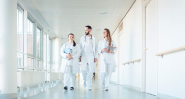 Grupa lekarzy stażystów korzystających z ubezpieczenia OC dobrowolnego i ochrony prawnej od INTER Polska idzie korytarzem.