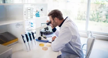 Diagnosta laboratoryjny w trakcie badania próbek korzysta z ubezpieczenia zdrowotnego i wsparcia zawodowego od INTER Polska.