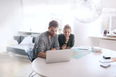 Para siedząca przy biurku przegląda ofertę online od INTER Polska - ubezpieczenia domu i mieszkania.