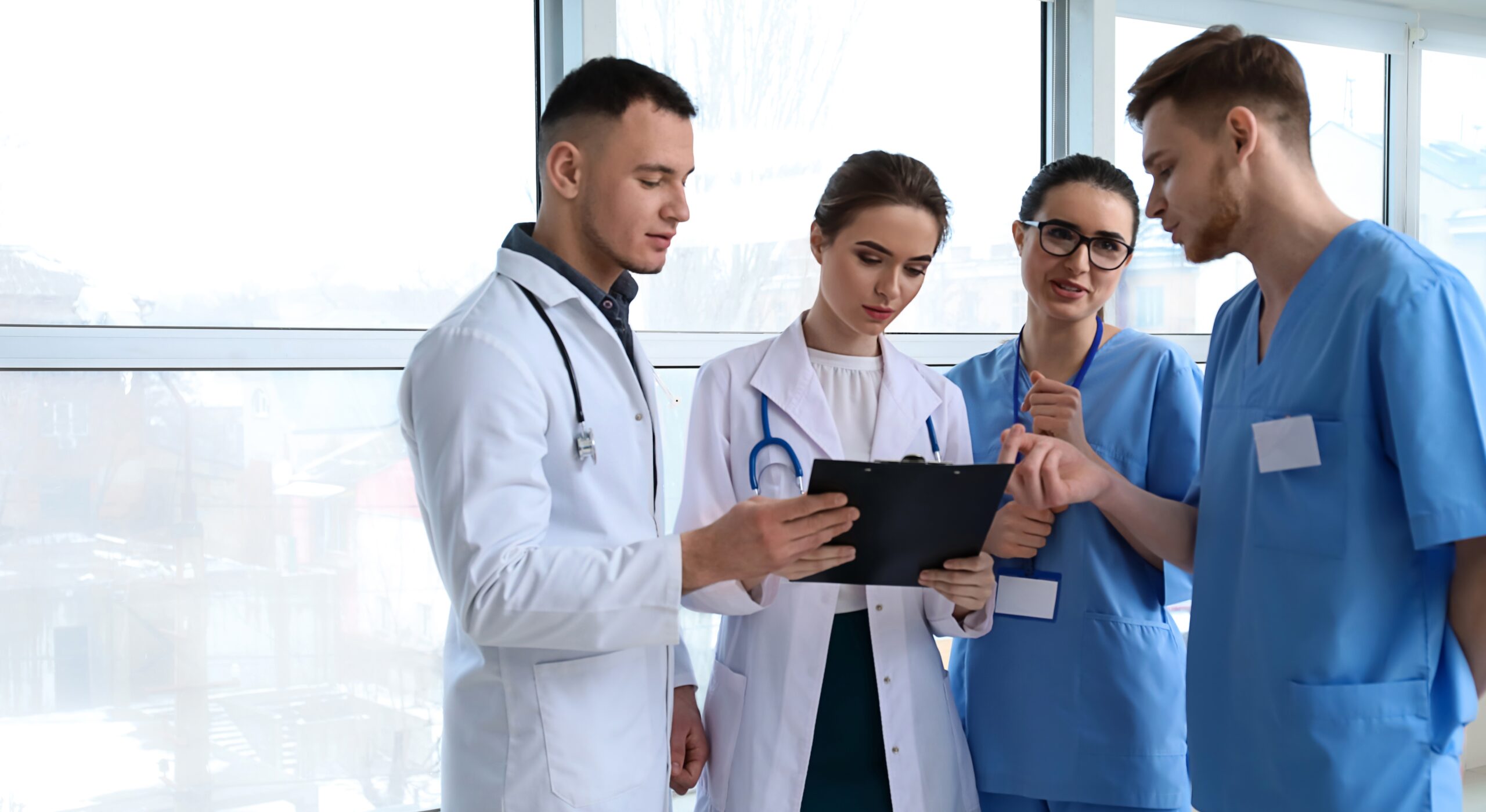 młodzi lekarze w szpitalu rozmawiają o diagnozie przeglądając wyniki badań na tablecie